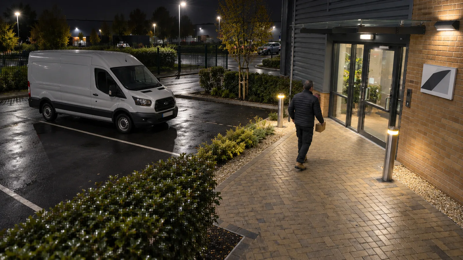 Clear HD CCTV image of a car park and building entrance at night