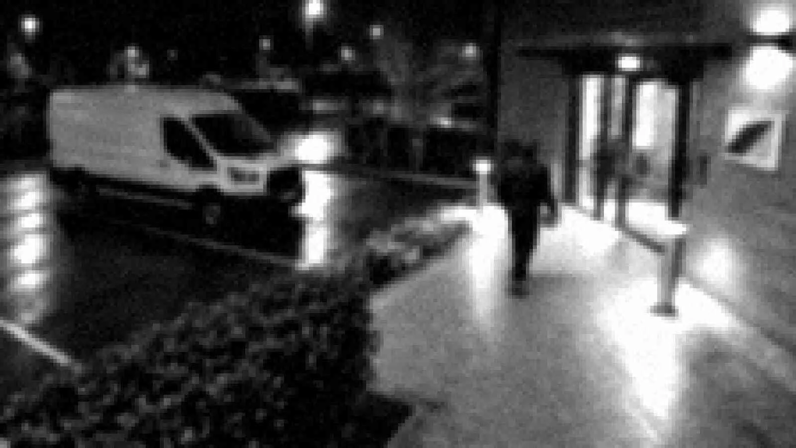 Grainy, low-resolution CCTV image of the same scene